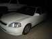 1997 Ford Probe - A white coupe is parked next to a white pickup truck at night.