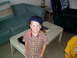 1986 Ford Bronco - A young boy sits indoors next to a toy car on a coffee table.