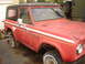 2006 Ford F1 - This red SUV features a distinctive white stripe along its side and a black hardtop.
