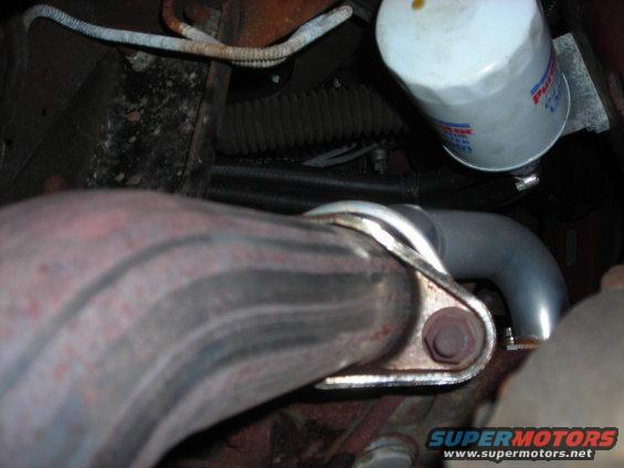 Exhaust pipe connection to engine with oil filter above