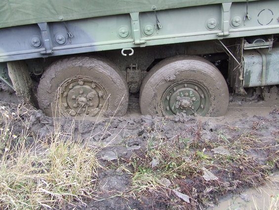 Military truck wheels stuck deep in mud