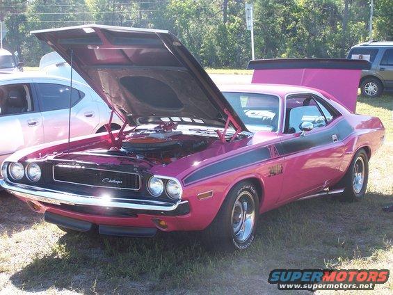 Pink 1973 Dodge Challenger with hood open, black stripes, and rear spoiler