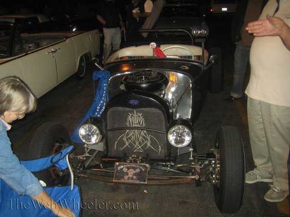 Hot rod with pinstripes on the grille, a skull license plate, and a blue cloth hanging from the hood