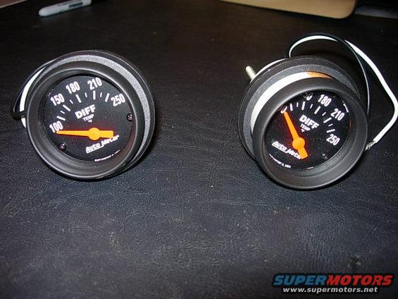 two AutoMeter differential temperature gauges on a dark surface