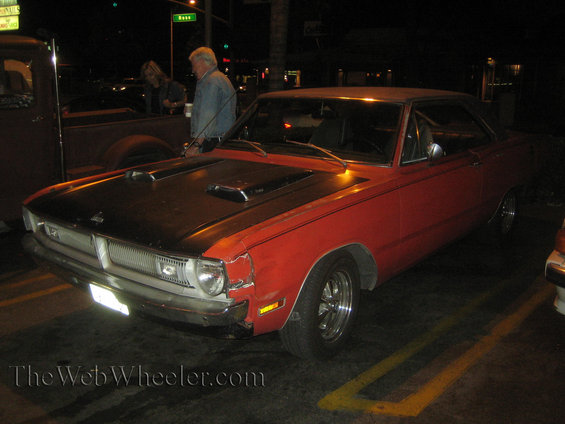Red 1970-1972 Dodge Dart with black hood scoops and a dented front fender