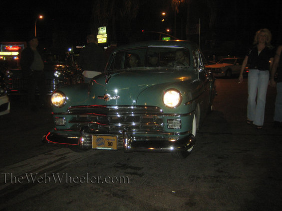 Green sedan with chrome grille and bumper, license plate reads '50'