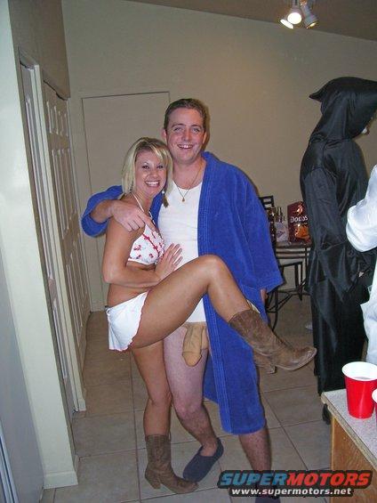Couple posing in costumes, with a person in a grim reaper costume in the background
