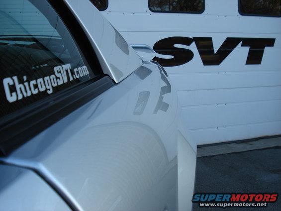 Silver car side view with ChicagoSVT.com sticker and SVT logo on garage door
