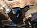 1973 Ford Ranchero - Underside view of a vehicle's exhaust headers and suspension system, showing engine components and rusty undercarriage.