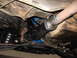 1973 Ford Ranchero - A close-up view of the exhaust system and drive shaft components underneath a vehicle.