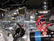 1973 Ford Ranchero - Close-up view of a vehicle's engine carburetor and ignition system components.