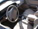 1995 Ford Taurus - The interior of a car features tan seats, a tan dashboard, and a center console with a gear shifter.