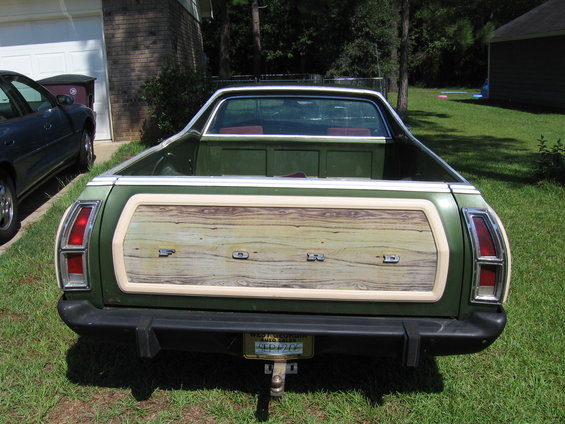 Rear view of green 1973 Ford Ranchero with woodgrain tailgate and 'FORD' lettering