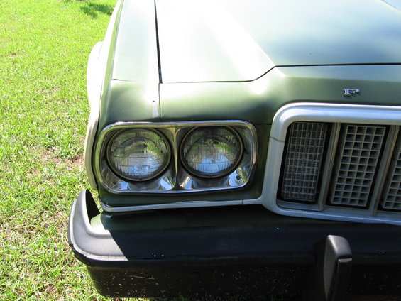 Front of a green 1972 Ford Ranchero showing headlights and grille