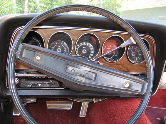 1973 Ford Ranchero interior with woodgrain dash, four gauges, and black steering wheel