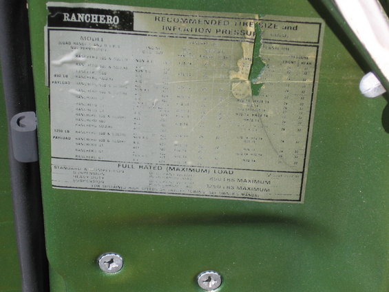 Green vehicle door with a white placard showing tire size and inflation pressure for a Ranchero