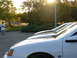 1995 Ford Taurus - A white sedan is parked in a lot with a person in the background.