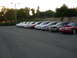1995 Ford Taurus - A row of sedans, likely Ford Taurus models from the 1990s, are parked in a lot at sunset.