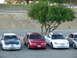 1995 Ford Taurus - Three Ford Taurus sedans are parked in a lot, with a tree providing shade.