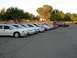 1995 Ford Taurus - Several sedans are parked in a lot, with a van and another car visible further back.