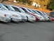 1995 Ford Taurus - A row of Ford Taurus sedans, including white and red models, are parked in a lot during the day.