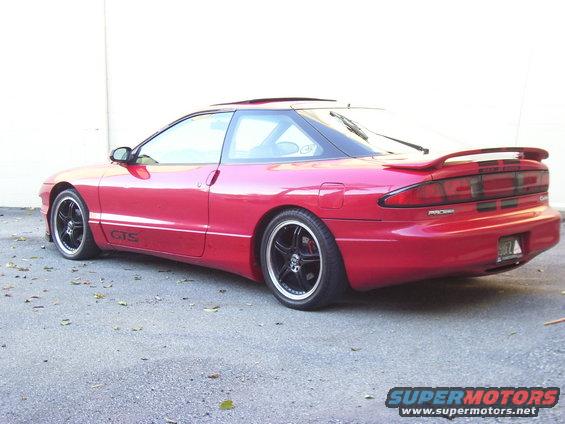 Red coupe with black rims, rear spoiler, and tinted windows