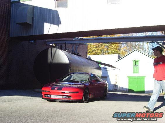 Red 1997 Ford Probe coupe with black racing stripes, front view, parked outdoors