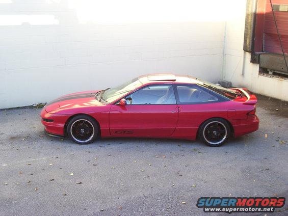 Red coupe with black racing stripes and 'GTS' badging on the side