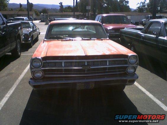 Front view of a red 1966 Ford Fairlane parked in a lot