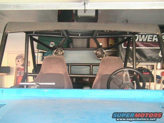 Interior view of a blue off-road vehicle with a roll cage, two bucket seats, and a steering wheel