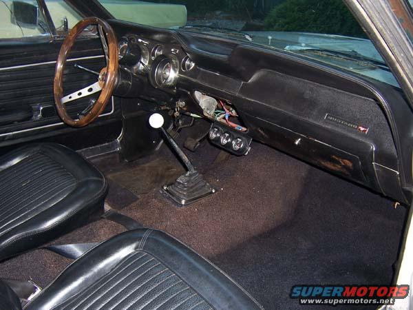 1968 Ford Mustang interior with wood steering wheel, dashboard, and shifter