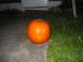 1997 Ford Crown Victoria - A carved pumpkin sits on a concrete walkway in front of a door.