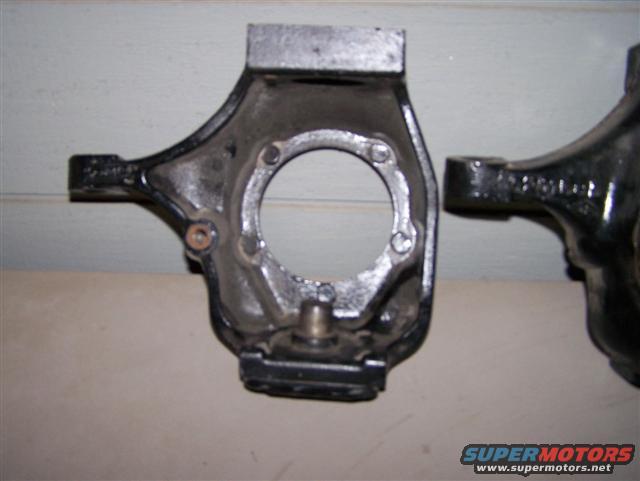 Close-up of two cast metal vehicle suspension components, likely steering knuckles