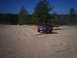 1996 Ford Bronco - A red Ford Bronco navigates a sandy landscape under a clear blue sky.