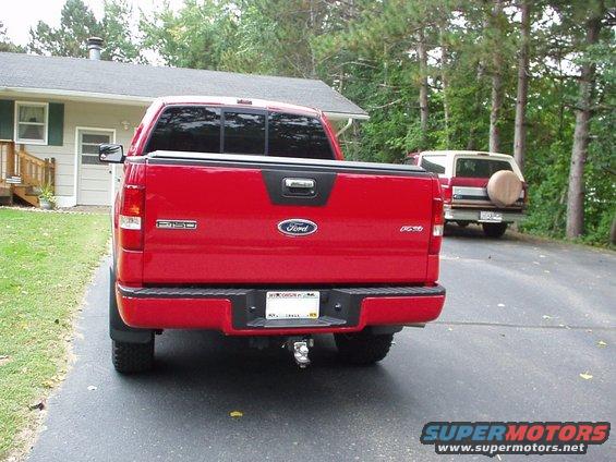 Red Ford F-150 rear view with a white Ford Bronco behind it