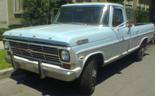 Light blue and silver Ford F-250 pickup truck, front 3/4 view, showing chrome bumper and grille