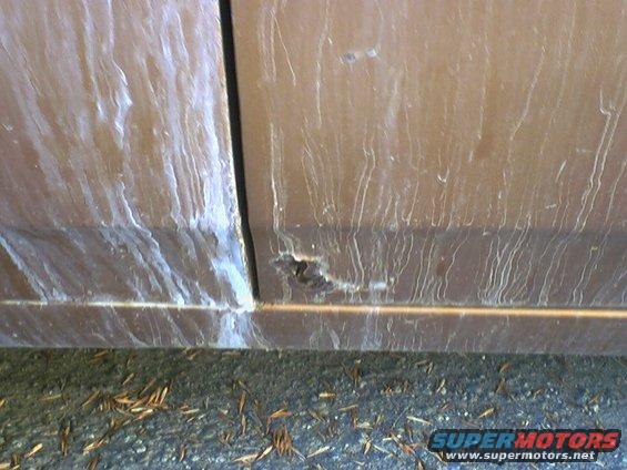 Close-up of rust and streaks on a brown car door
