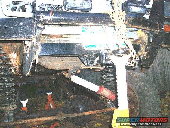 Vehicle undercarriage with jack stands, suspension components, and a chain hoist