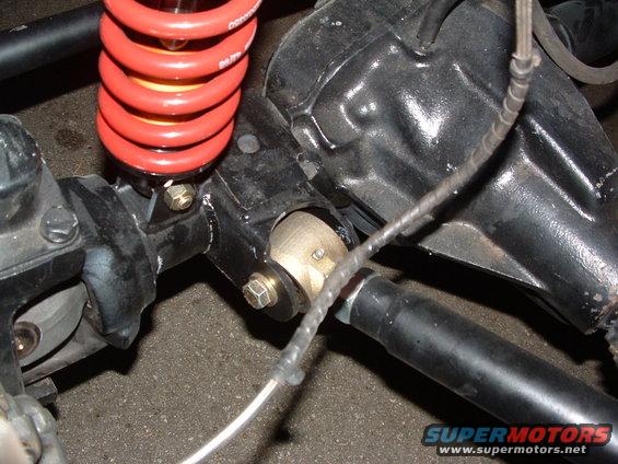 Close-up of a red coilover shock and black suspension components on a vehicle