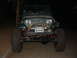 1994 Jeep YJ - Front view of a green 1994 Jeep YJ equipped with a winch and oversized tires.