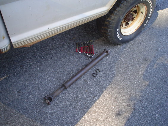 1967 Ford F-250 driveshaft and wrenches on asphalt