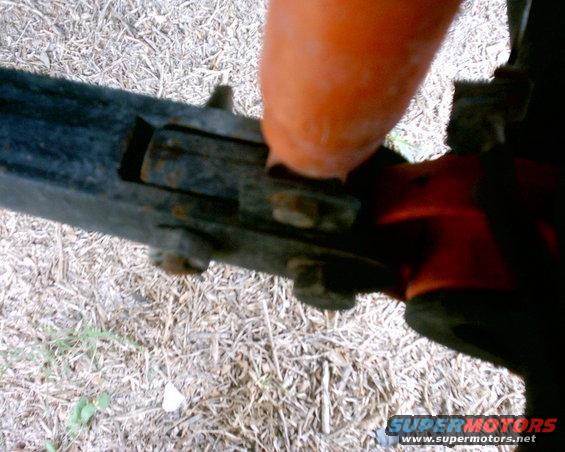 Orange component bolted to black frame