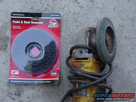 Paint and rust remover disc next to a yellow angle grinder with a green abrasive disc