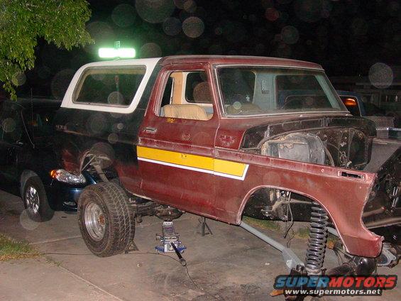 1979 Ford Bronco, maroon with white top and yellow stripe, front end removed, on jacks