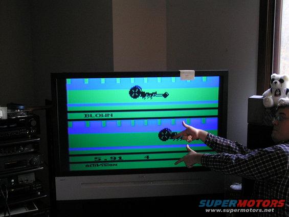 Television displaying a video game with pixelated figures and text