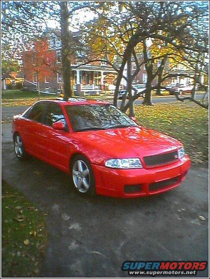 Red 1997 Audi A4 sedan parked on a driveway in front of a house