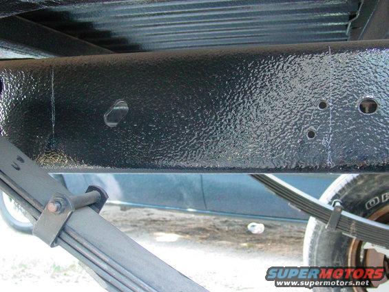 Close-up of vehicle frame and leaf spring assembly