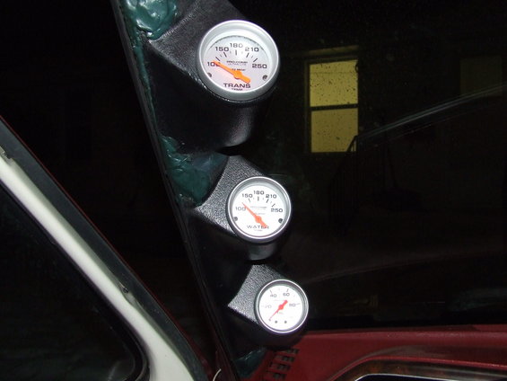 Triple gauge pod with transmission temperature, water temperature, and oil pressure gauges mounted on a car's interior pillar