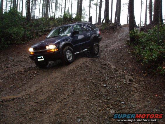 Dark blue SUV on a muddy forest trail