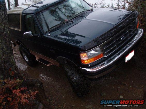 1995 Ford Bronco on a muddy trail with trees